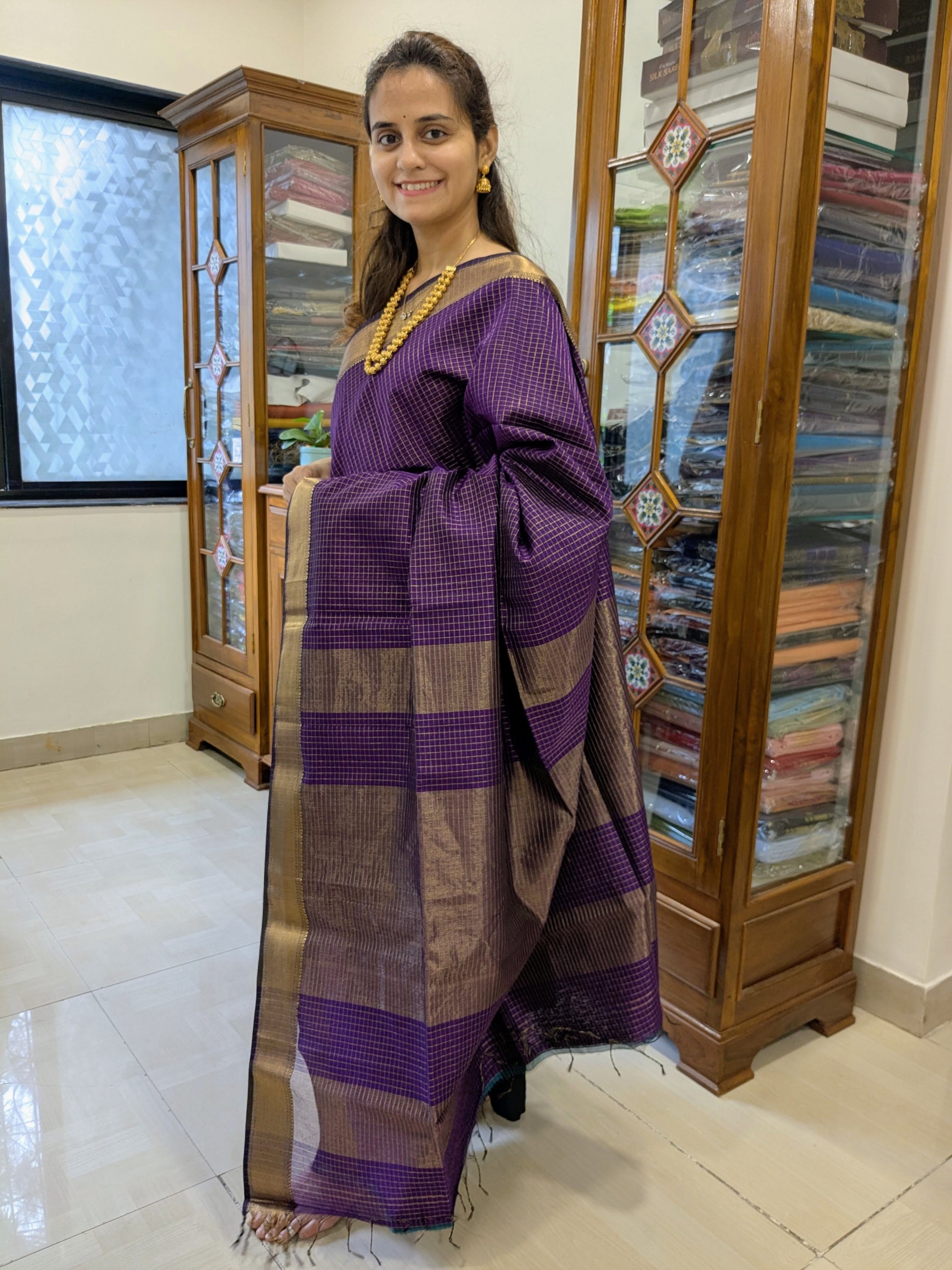 Full front view of festive purple handloom Maheshwari saree featuring golden zari check patterns and elegant texture.