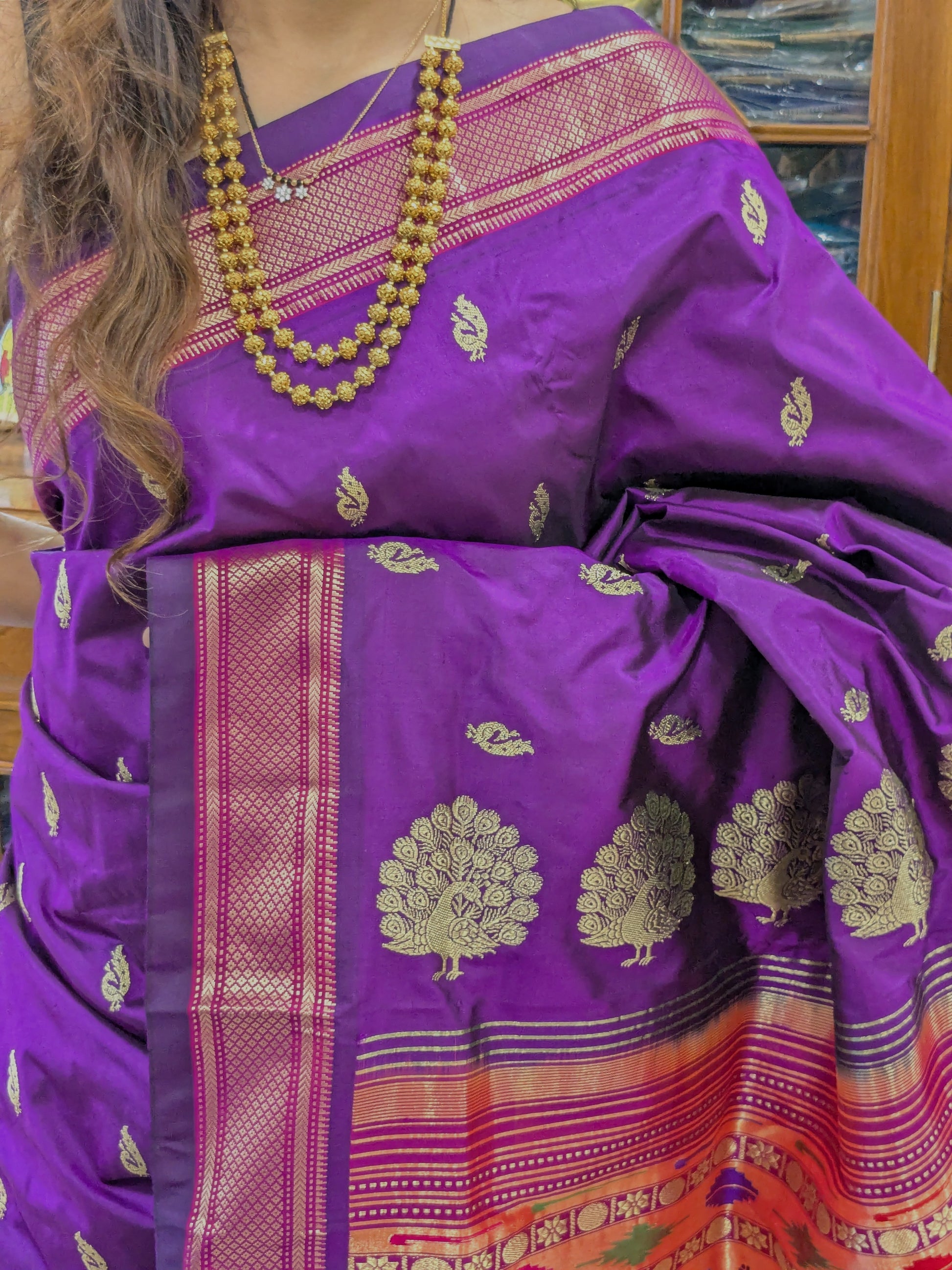 Close-up of pure silk purple Paithani saree with intricate full peacock butti and traditional Narali border.