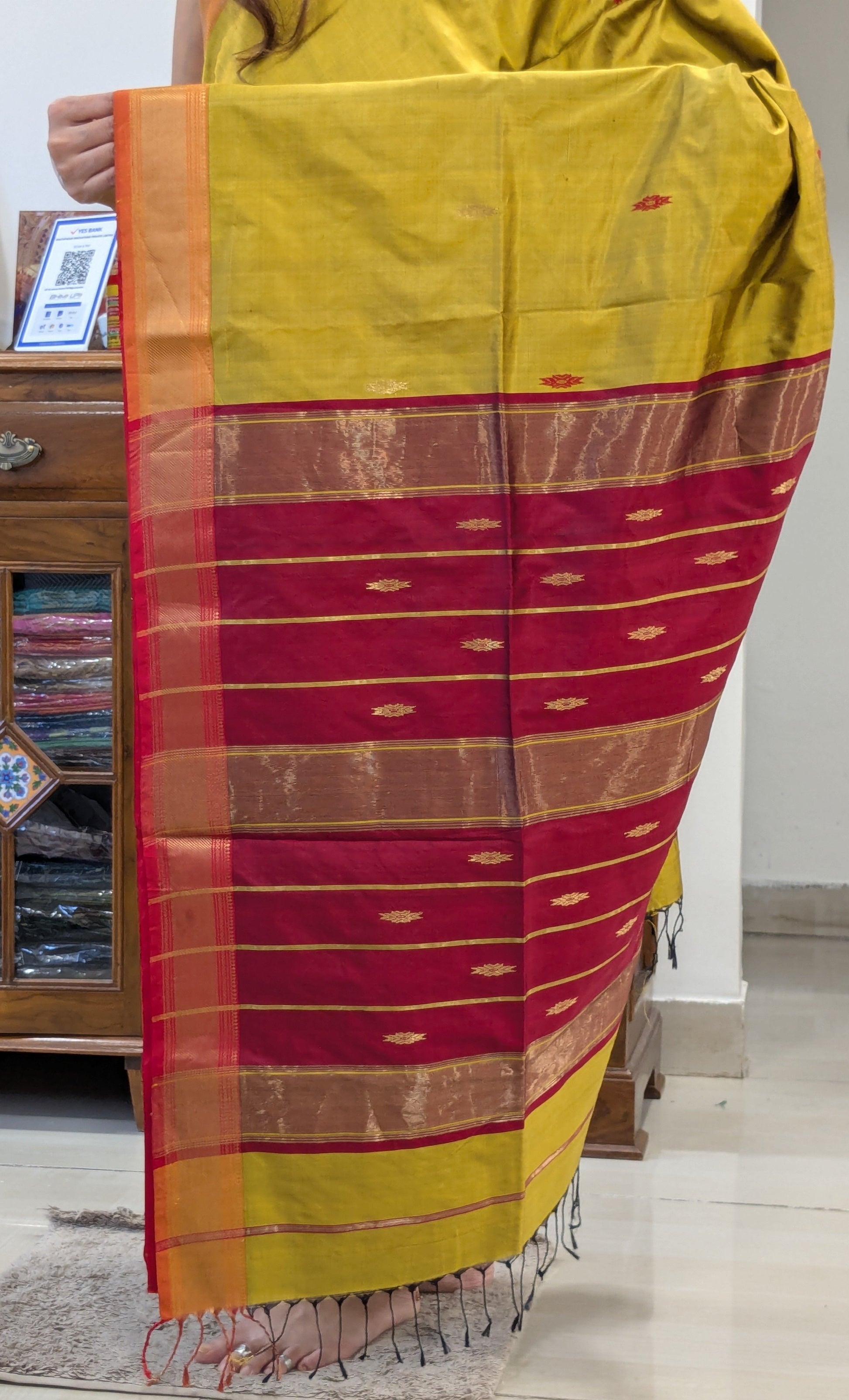 Detailed pallu with traditional butticar weaving in shimmering silk.