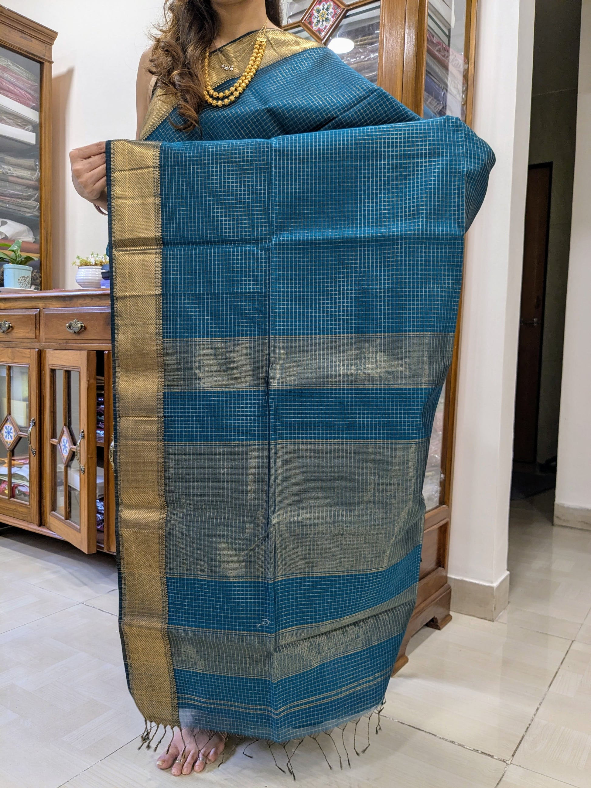 Detailed pallu image with shimmering zari checks reflecting Maheshwari craftsmanship.