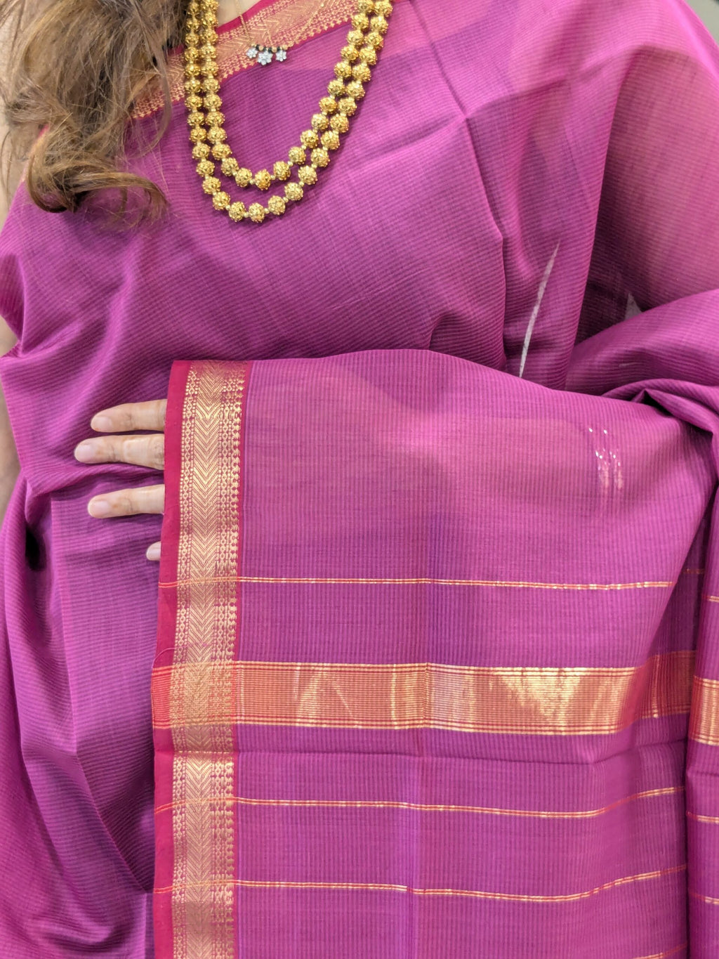 Close-up of onion pink Maheshwari silk-cotton saree with striped pattern, small zari border