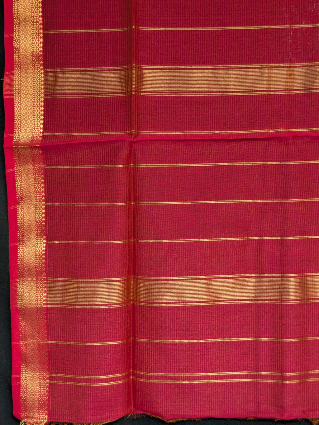Detailed image of zari-lined pallu featuring shimmering gold lines woven with fine craftsmanship.  