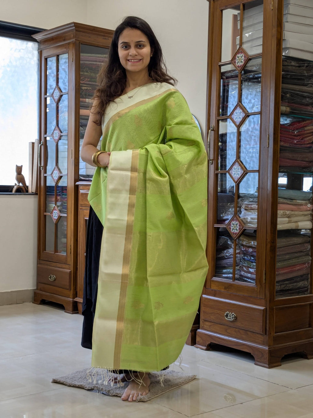 Full front view of elegant pista green handloom Maheshwari saree featuring subtle flower motifs and shimmering zari pallu.  