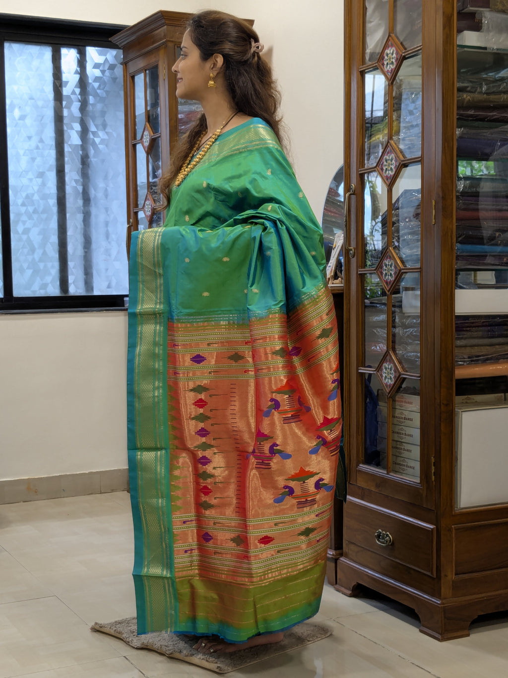 Side view capturing the graceful Narali border and flowing silk that flatters every silhouette.