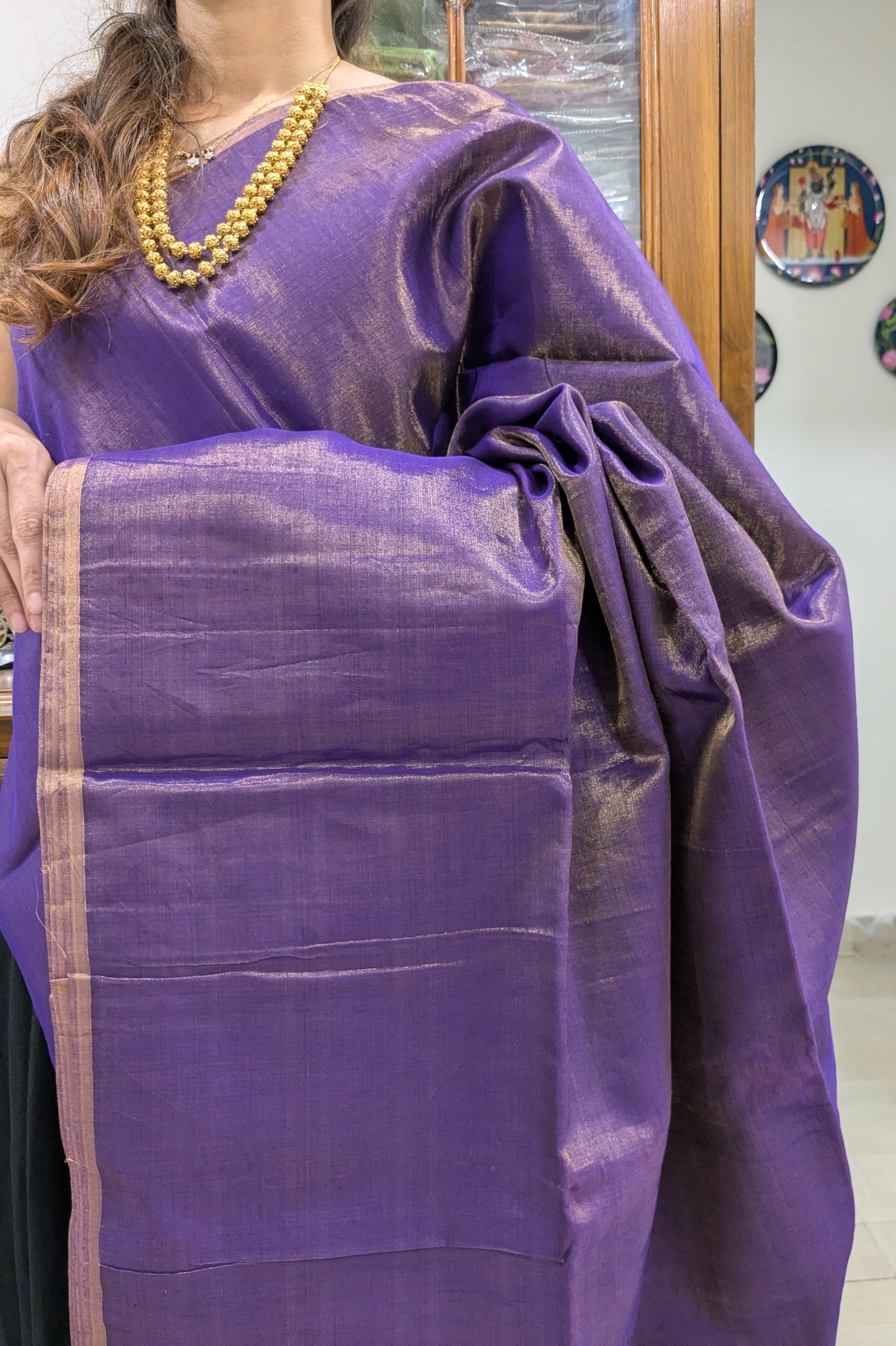 Close-up of purple Maheshwari saree in tissue-cotton with plain handloom weave and smooth texture.
