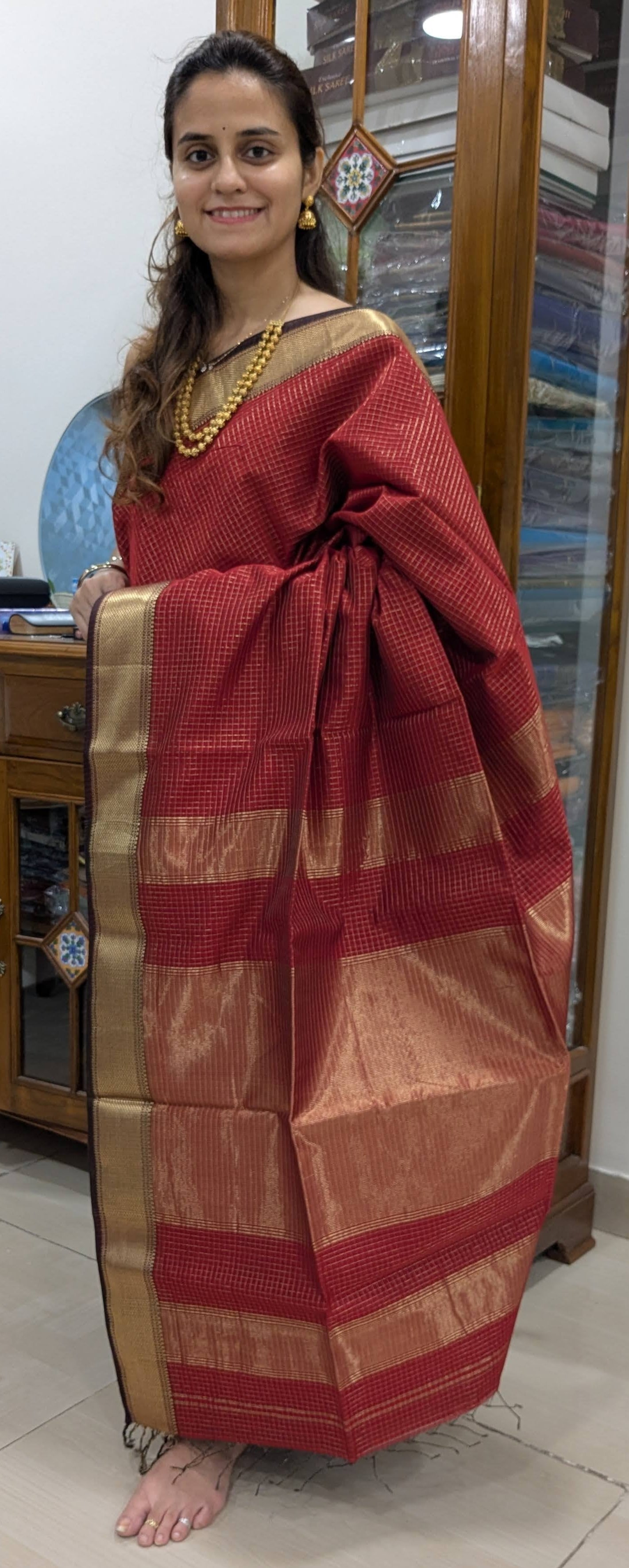Full front view showing festive red hue and shimmering zari-checked Maheshwari weave.