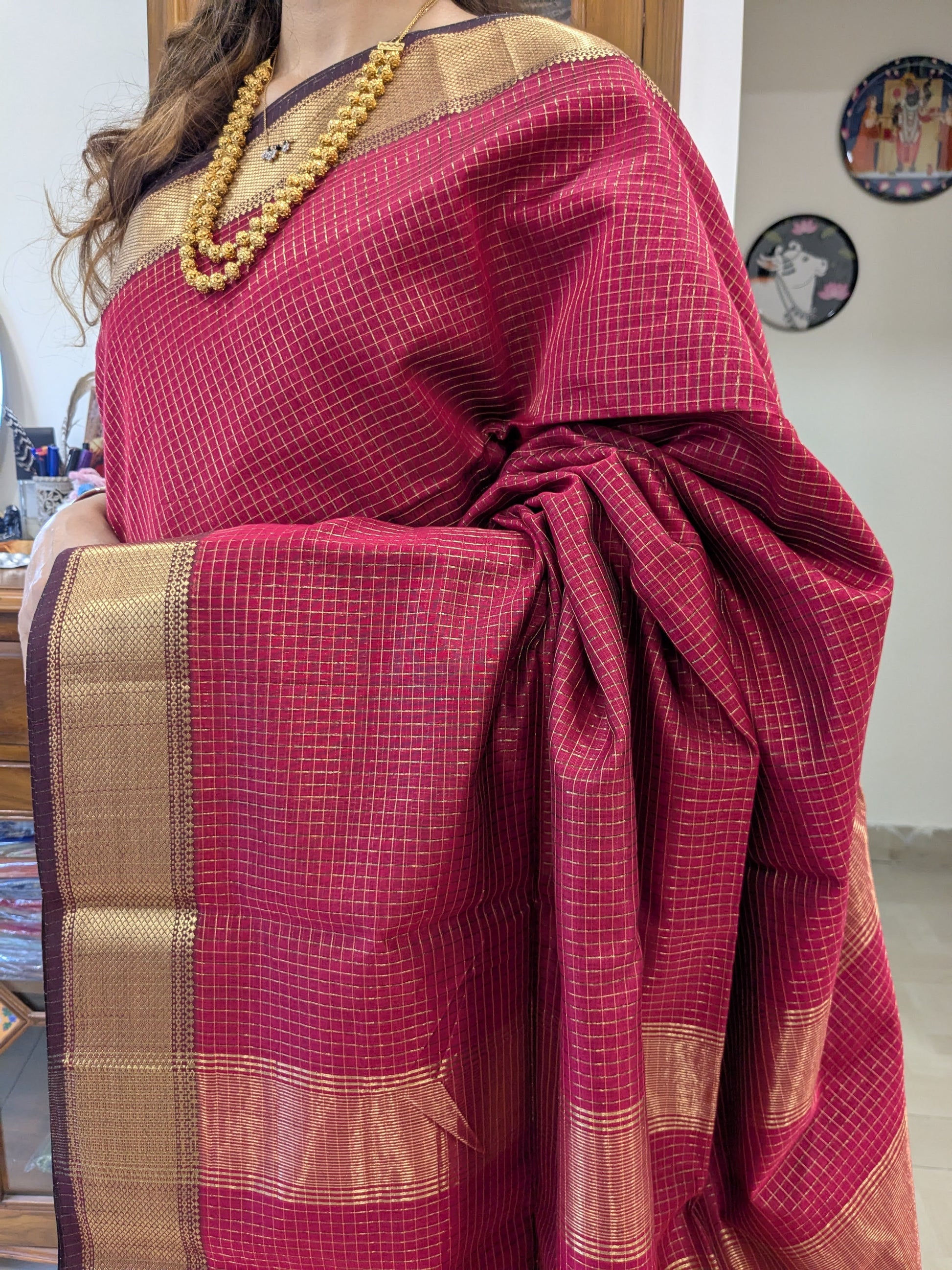 Close-up of fresh red Maheshwari silk-cotton saree with zari checks, medium border