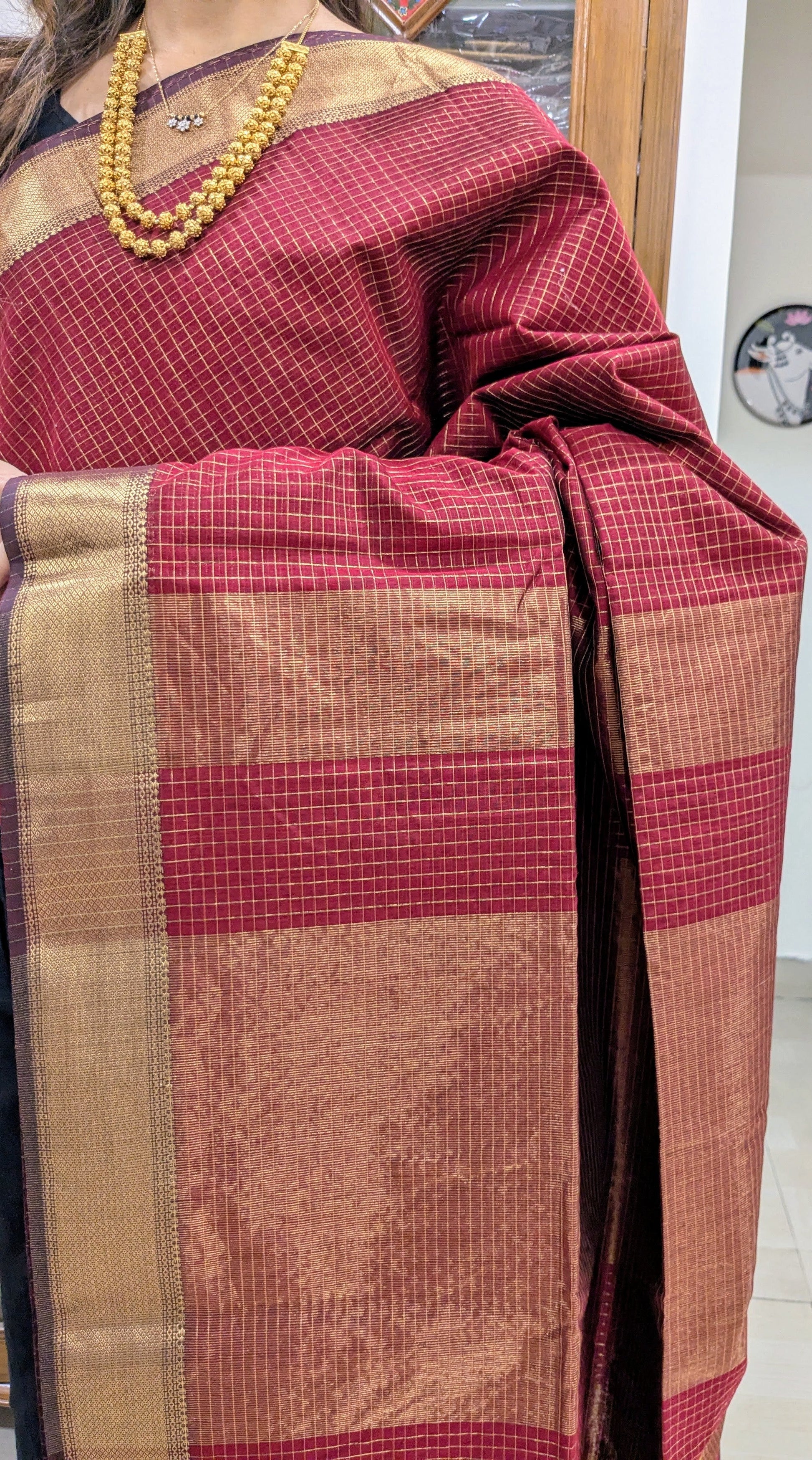 Close-up of Tomato Red Maheshwari saree featuring silk-cotton fabric, zari checks, and handwoven medium border.