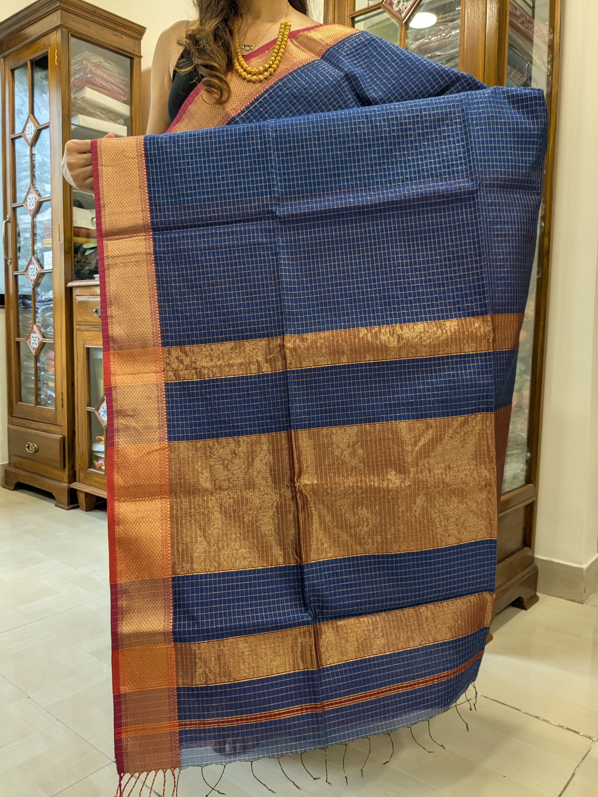 Detailed image of zari-checked pallu with fine gold threadwork in timeless Maheshwari style.
