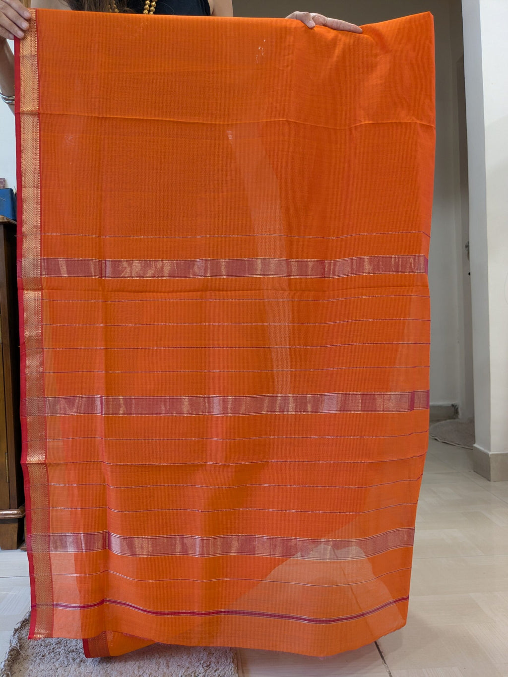 Detailed image of zari-lined pallu with shimmering gold lines crafted in fine Maheshwari style.  