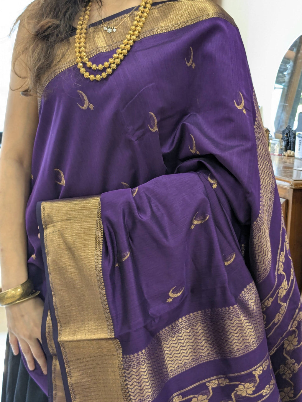 Close-up of purple Maheshwari saree with moon and flower motifs, wide-narrow border