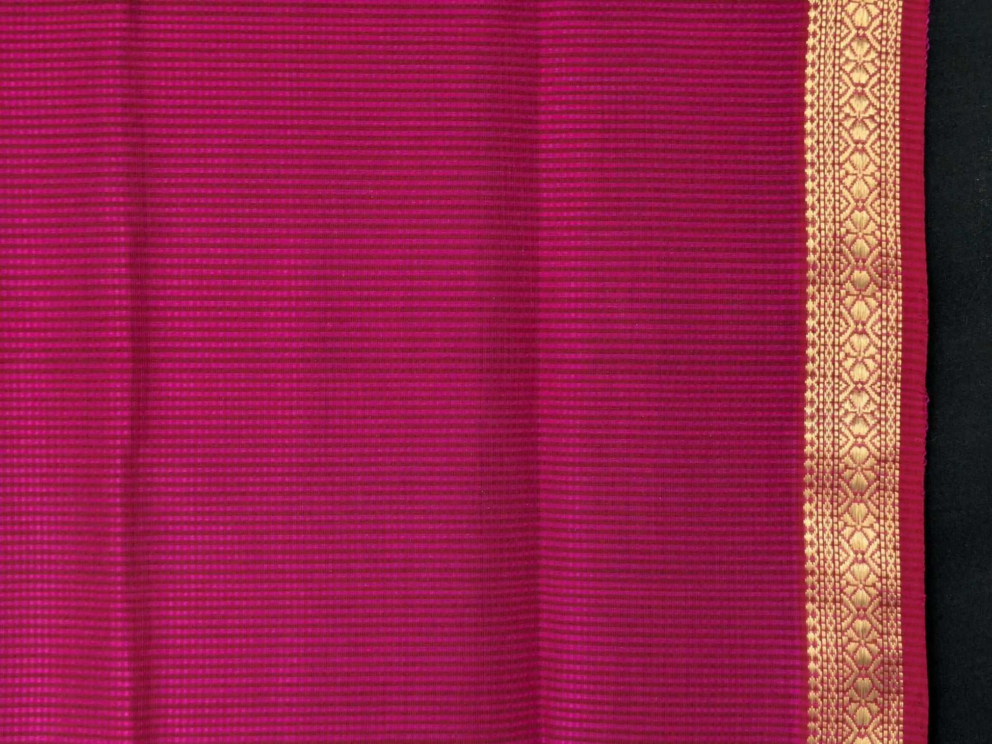 Close-up of hot pink Maheshwari saree with small checks, vintage-style pallu, and small zari border in silk-cotton blend.
