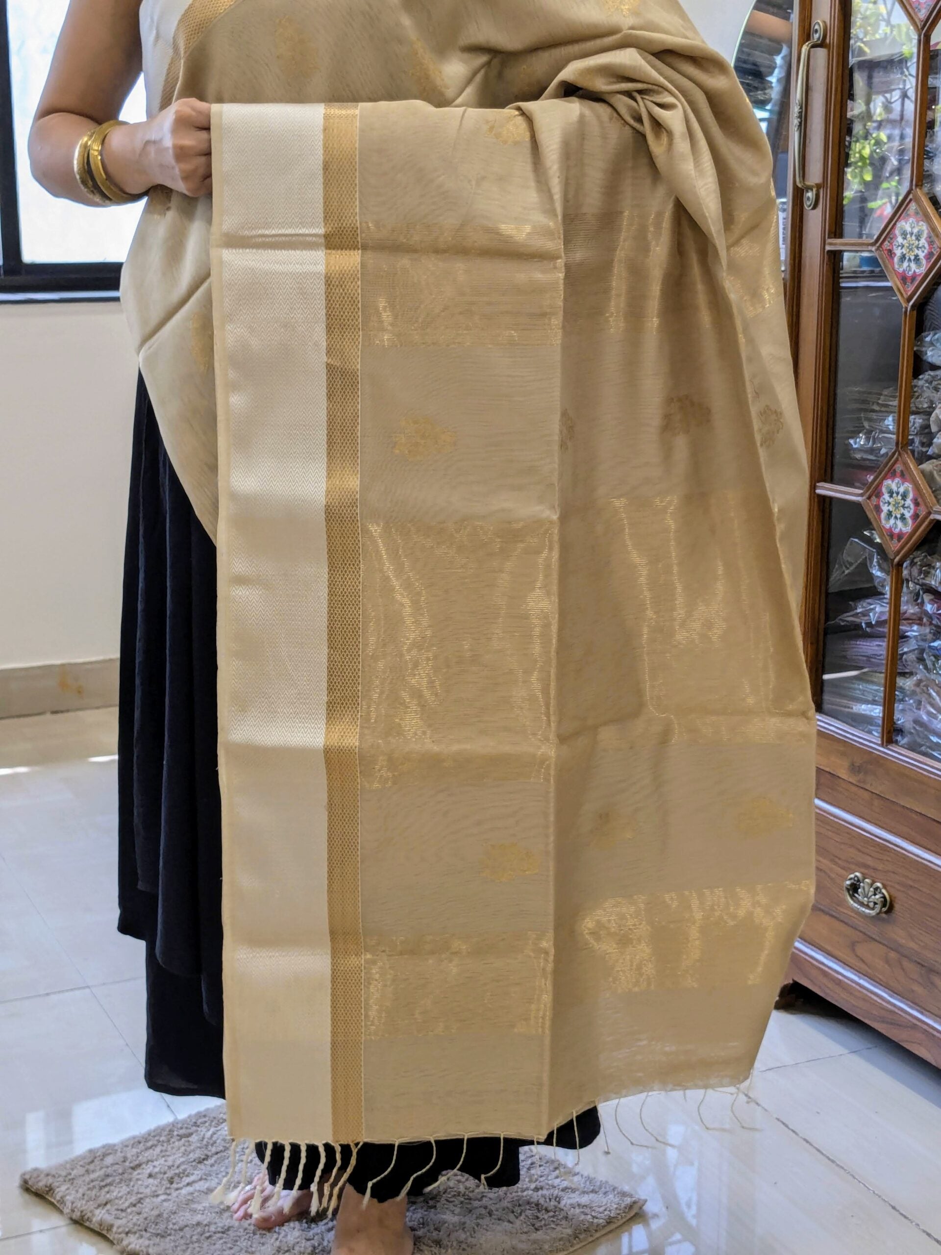 Detailed image of zari-lined pallu with understated floral accents and shimmering gold threads.