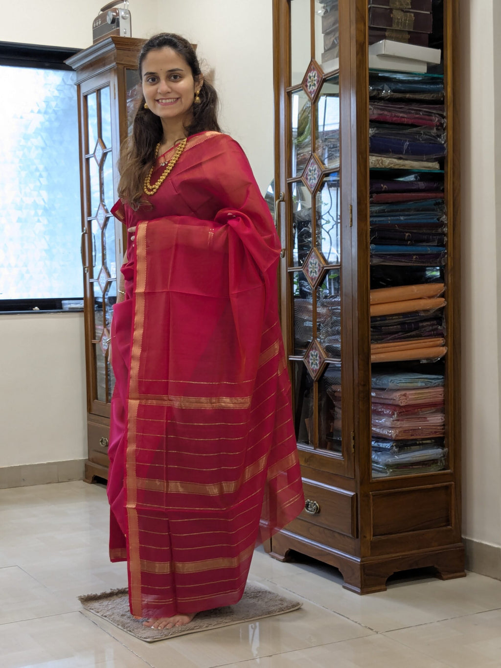 Full front view of vibrant rani pink handloom Maheshwari saree with linear design and subtle golden highlights. 