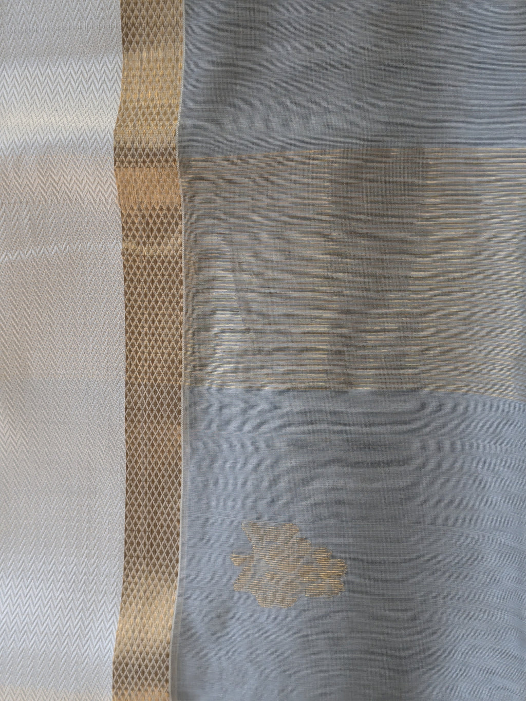 Detailed image of zari-lined pallu with delicate floral elements and understated shimmer.