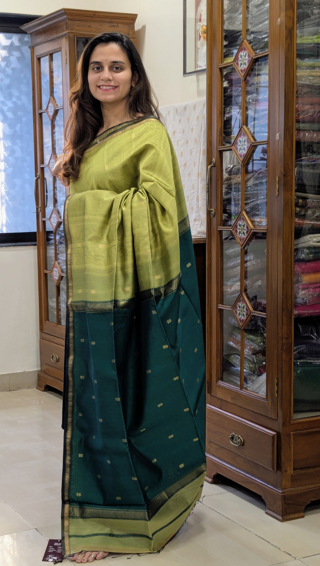 Woman wearing a light and dark green saree