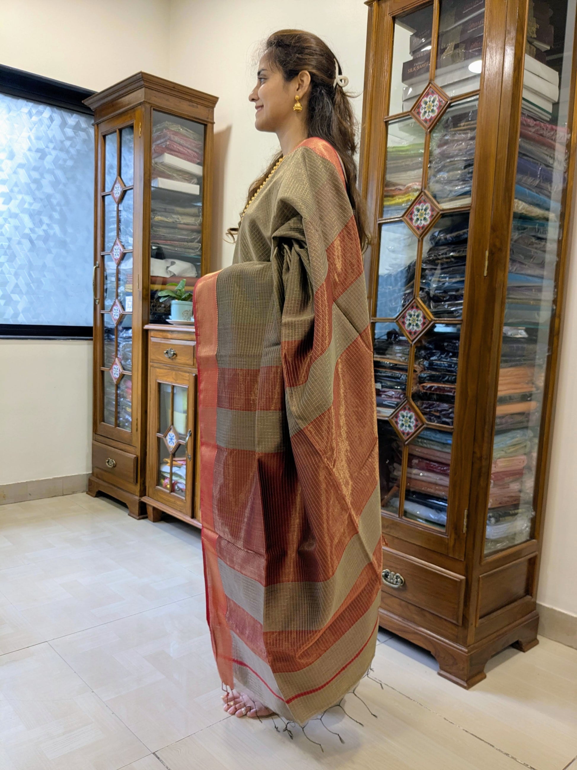 Side view of grey saree showcasing graceful drape, traditional weave, and rich silk-cotton texture.