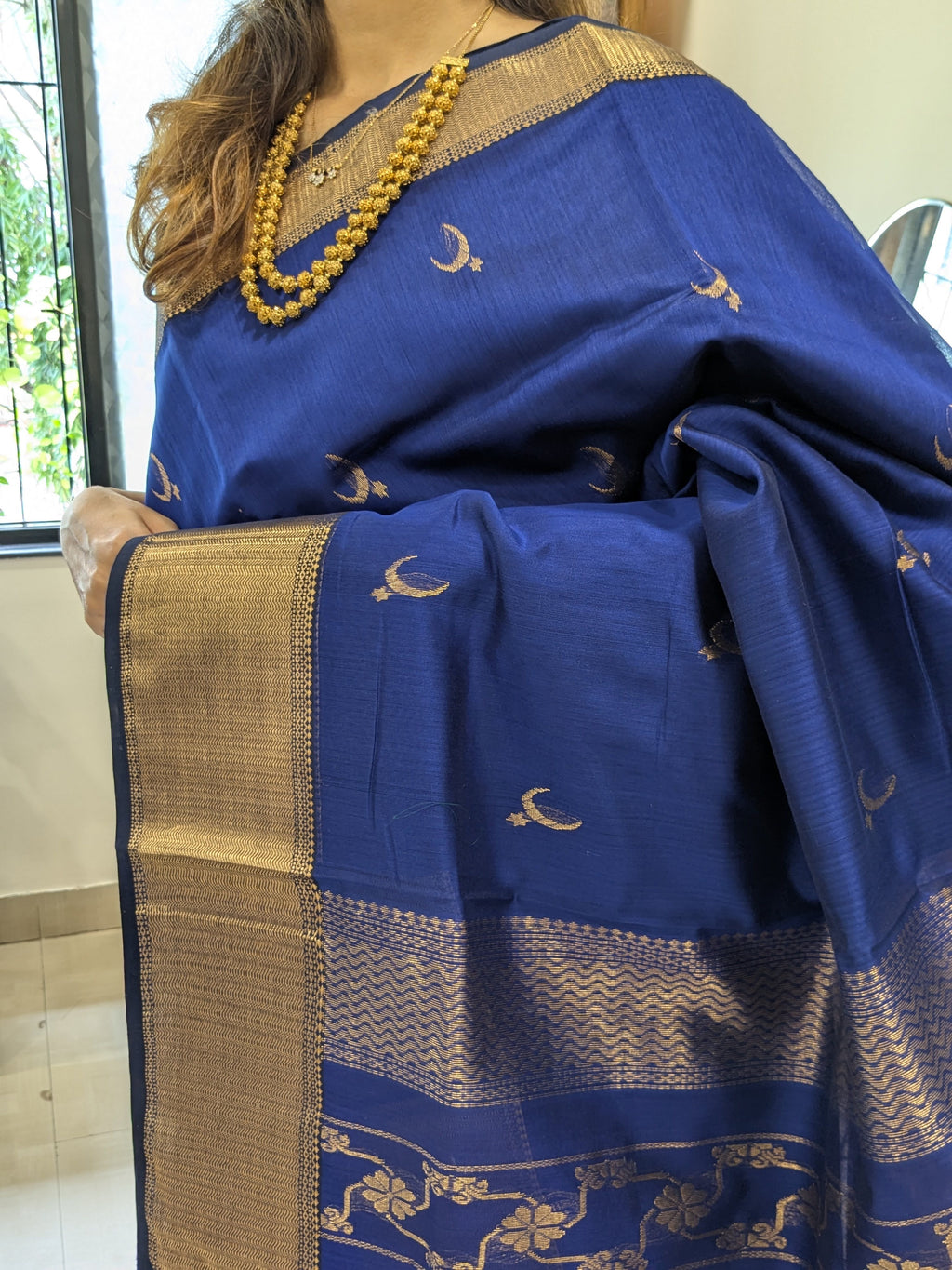 Close-up of Royal Blue Maheshwari saree with moon-flower motifs and ornate jaali pallu transition.