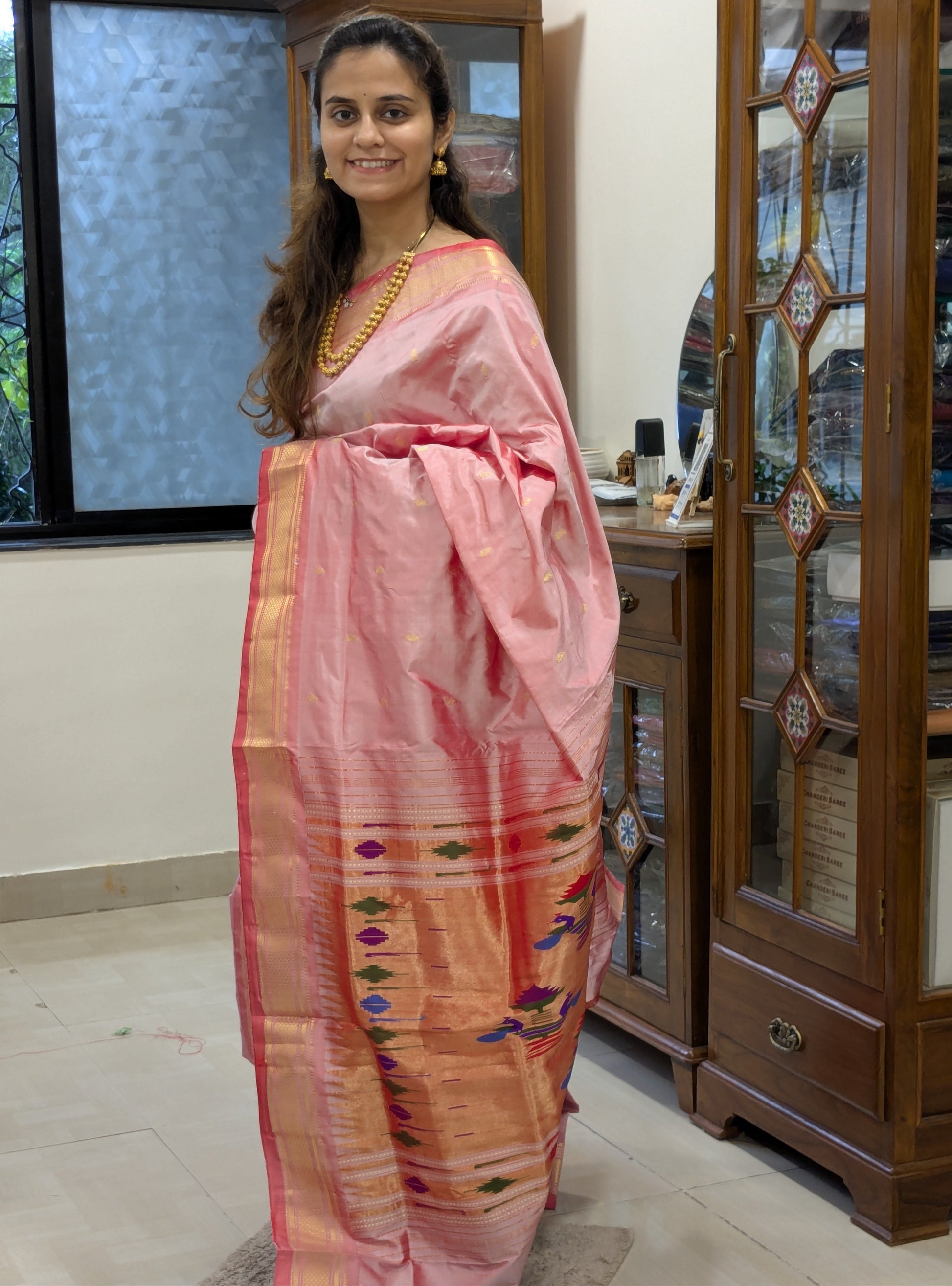 Full front view showcasing the regal Paithani drape with vibrant peacock designs on the pallu.