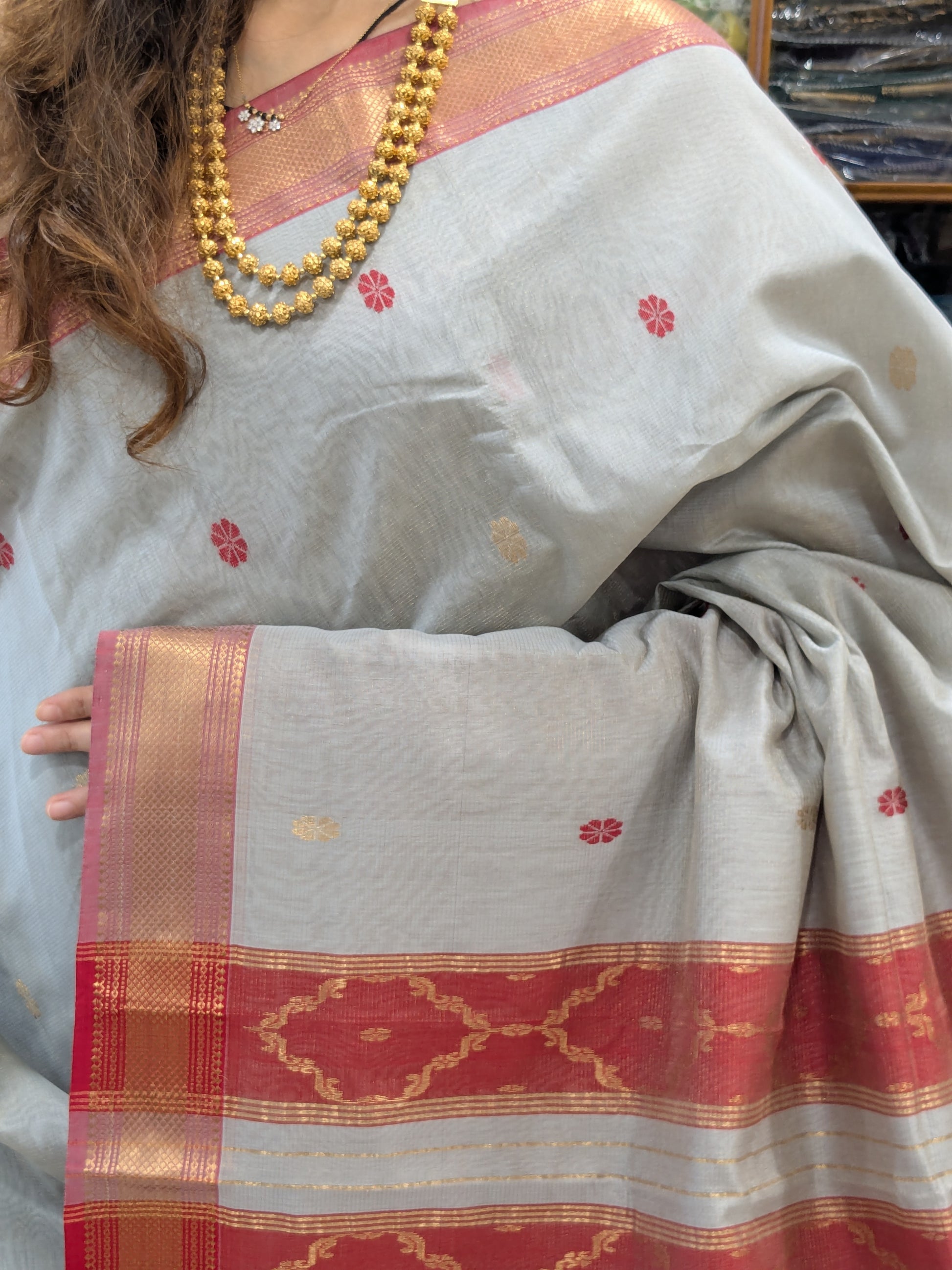 Close-up of Silver Grey silk tissue Maheshwari saree with flower butti, jaali pallu, and intricate medium border.