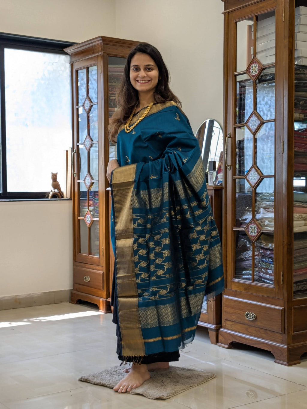 Full front view of festive silk-cotton Maheshwari saree in peacock green with traditional motifs and rich texture.