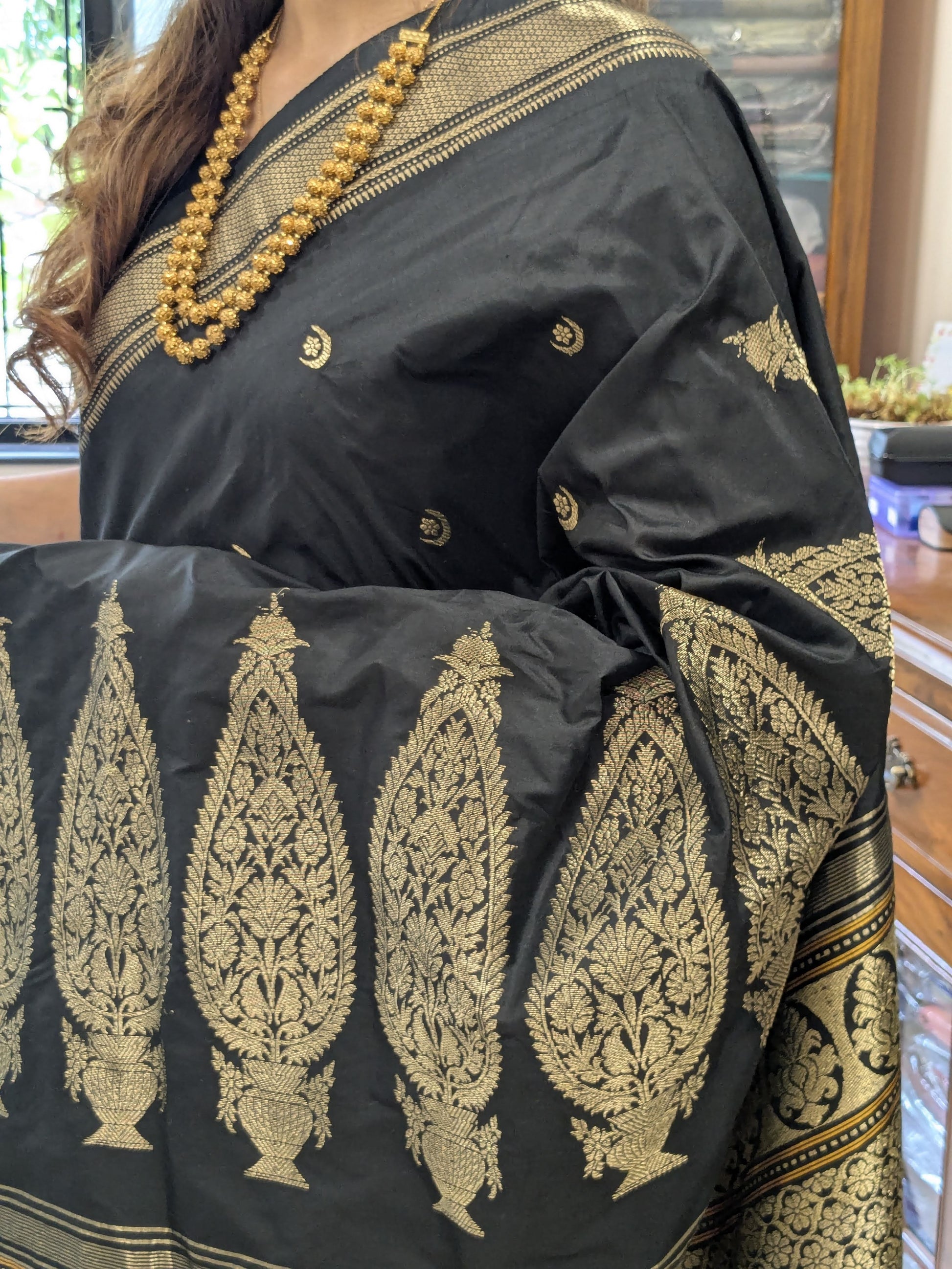 Close-up of black pure silk Paithani saree with moon and flower motifs, traditional Narali border
