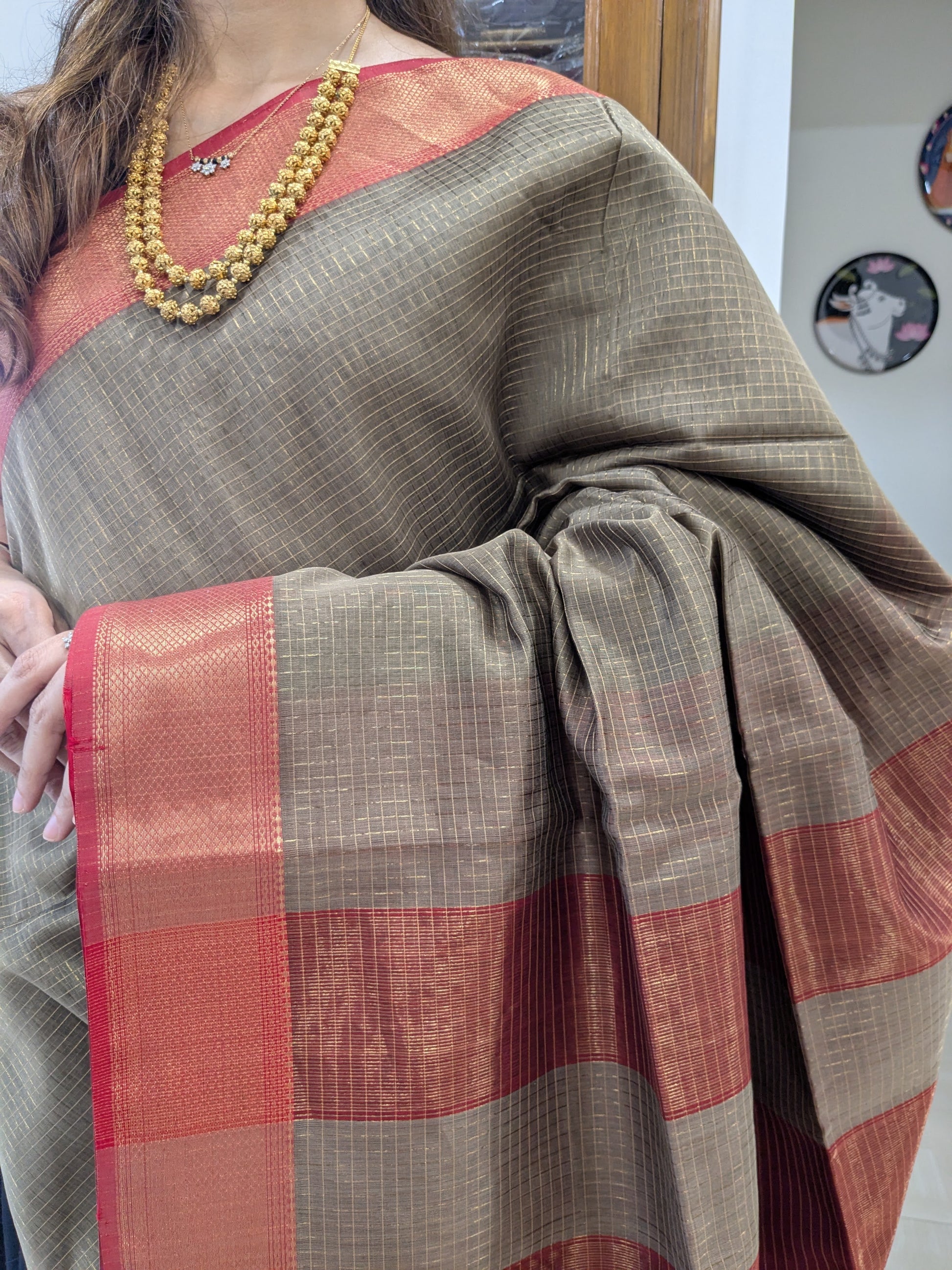 Close-up of grey Maheshwari silk-cotton saree with zari checks, medium border