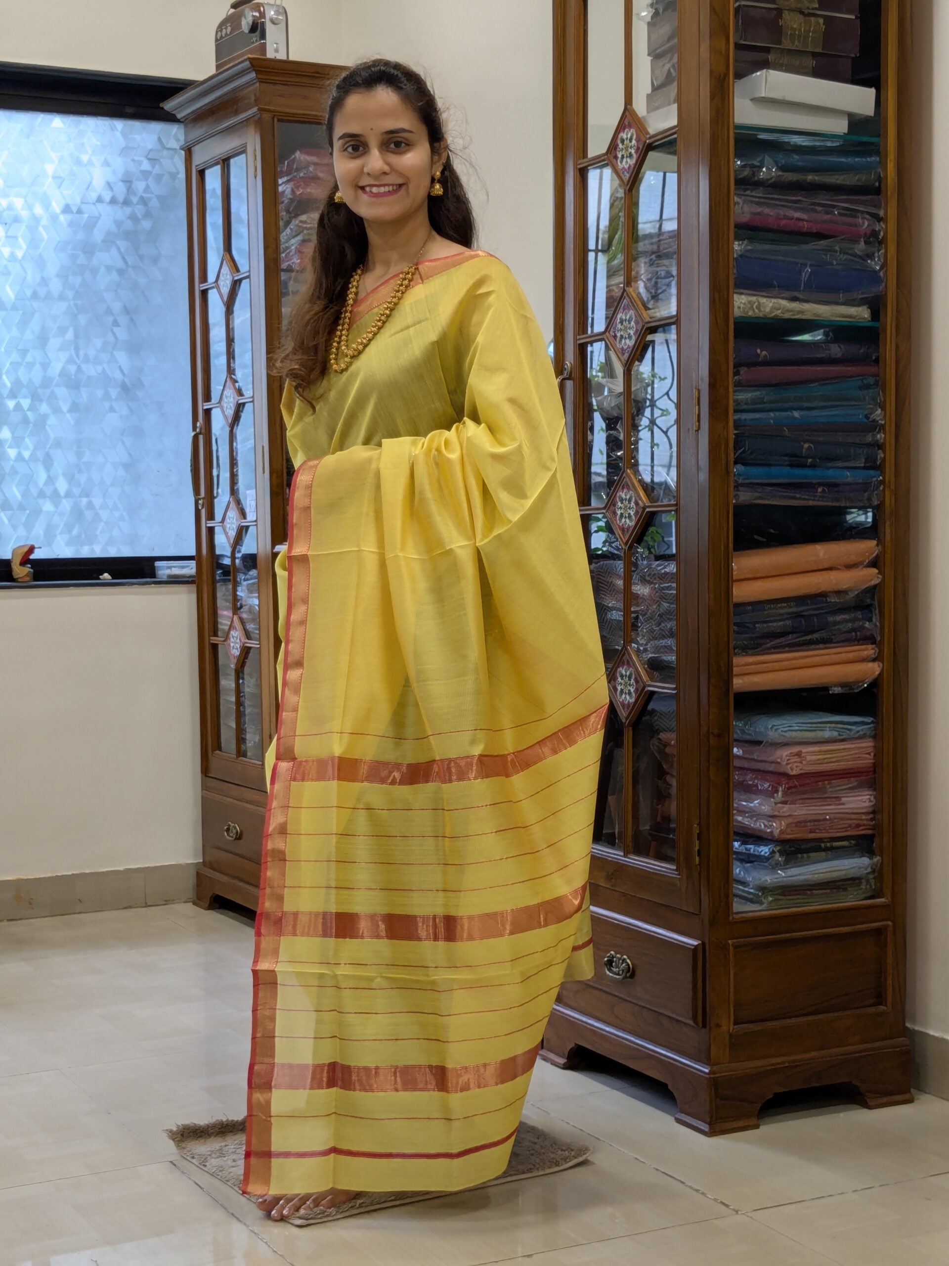 Full front view of handloom yellow Maheshwari saree featuring linear design and subtle festive shimmer.