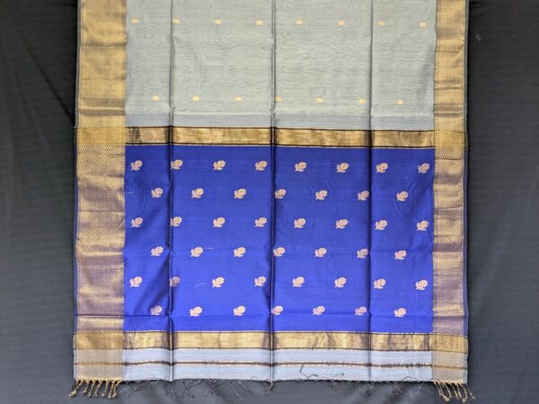 Detailed image of blue buttidar pallu with traditional flower motifs and shimmering handwoven texture.