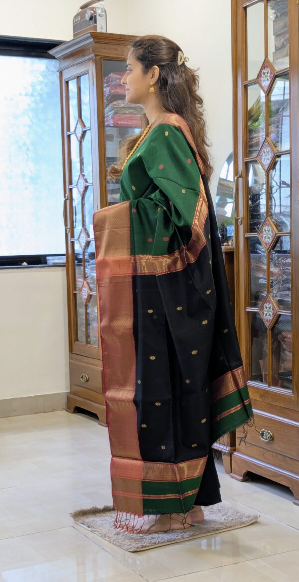 Side view of green saree showing elegant drape, handwoven texture, and bold black accents.