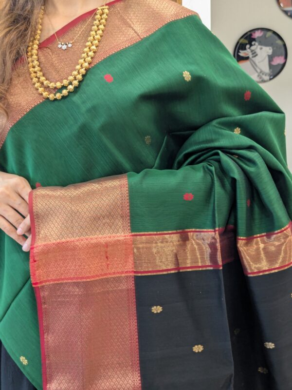 Close-up of green and black Maheshwari silk-cotton saree with flower butti motifs, wide & narrow border