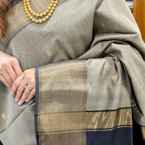 Close-up of grey and black Maheshwari saree with flower butti motifs, wide-narrow border