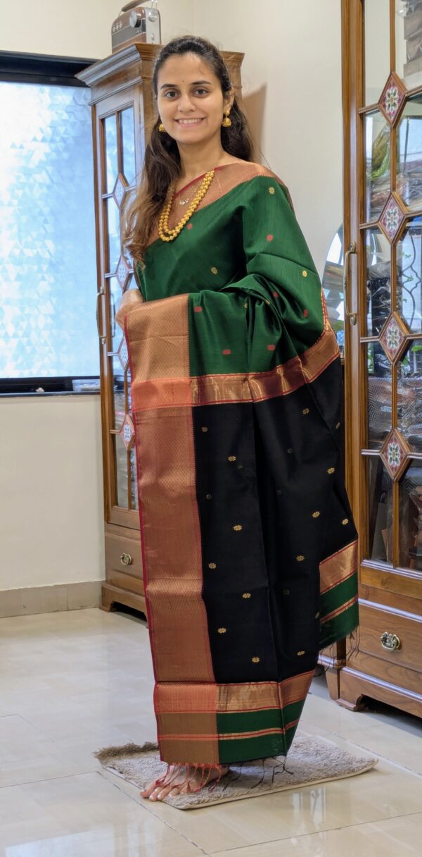 Full front view of festive green handloom Maheshwari saree featuring delicate floral motifs and contrasting black pallu.