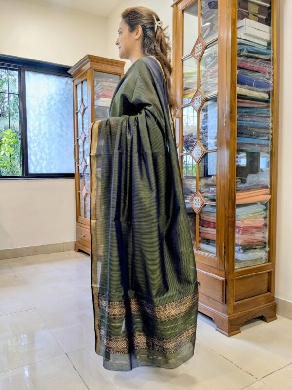 Side view of lightweight olive green saree showcasing elegant drape and handwoven texture.