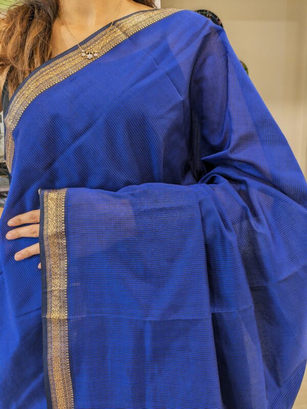 Close-up of royal blue Maheshwari saree with small checks, vintage pallu transition, and delicate zari border in silk-cotton blend.