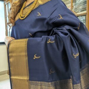 Close-up of deep blue Maheshwari saree featuring moon and flower motifs, wide-narrow border