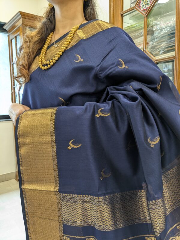 Close-up of deep blue Maheshwari saree featuring moon and flower motifs, wide-narrow border