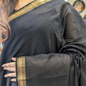 Close-up of black Maheshwari handloom saree with small checks, zari border.