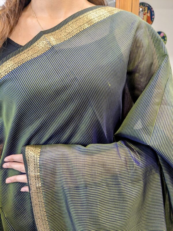 Close-up of olive green Maheshwari saree with small checks, zari border