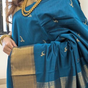 Close-up of peacock green Maheshwari saree with moon and flower motifs, wide-narrow border