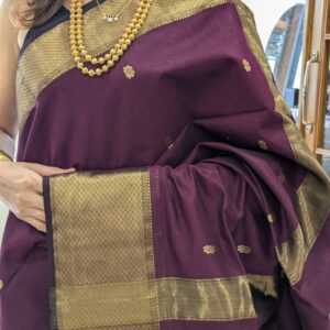 Close-up of plum purple Maheshwari silk cotton saree with flower butti, resham border