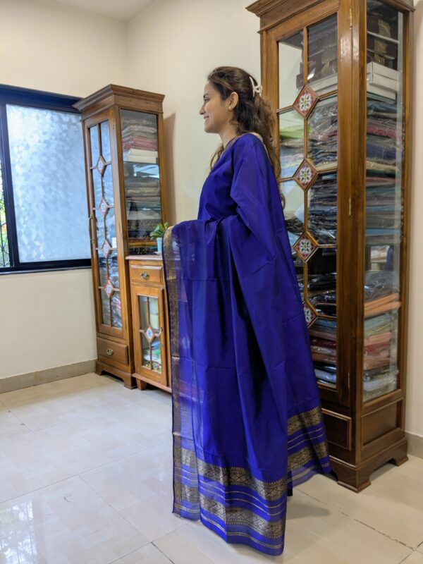 Side view showing graceful drape of handwoven purple saree with subtle texture and sheen.