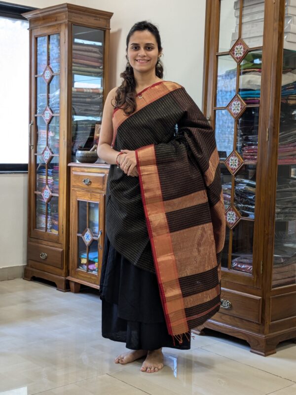 Full front view of festive black silk-cotton Maheshwari saree with all-over zari check design and rich texture.