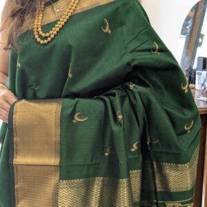 Close-up of bottle green Maheshwari saree with moon and flower motifs, wide-narrow border