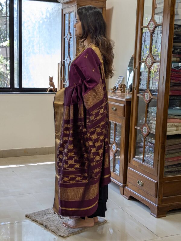 Side view of handwoven plum saree showing rich drape and detailed moon-flower design.