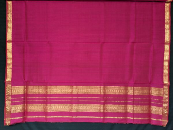 Close-up of hot pink Maheshwari saree with small checks, vintage-style pallu, and small zari border in silk-cotton blend.