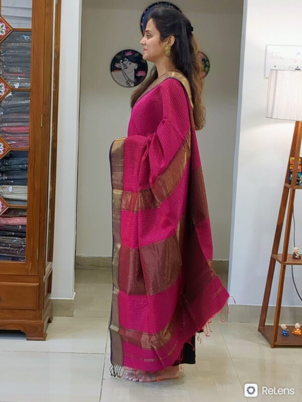 Side view of dark rani pink saree showing rich drape, handwoven finish, and intricate golden check pattern.