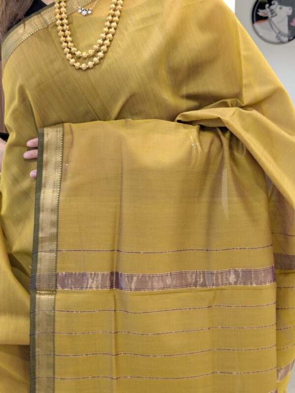Close-up of sonsali golden Maheshwari silk-cotton saree with linear patterns, small zari border