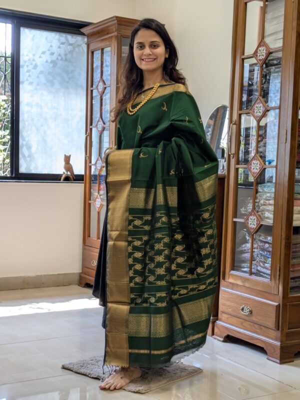 Full front view of festive bottle green silk-cotton Maheshwari saree featuring intricate motifs and traditional weave