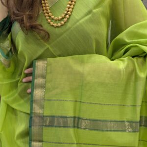 Close-up of parrot green Maheshwari silk-cotton saree with linear design, small zari border
